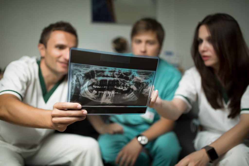 Dentists looking at teeth x-ray