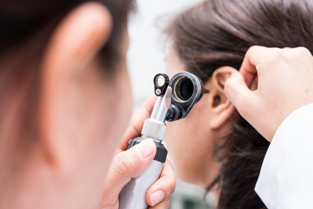 Doctor examined the patient's ear with Otoscope