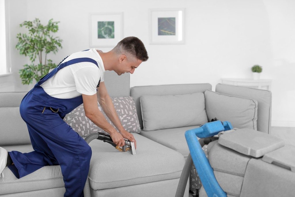 man cleaning the couch