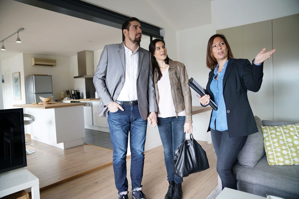 Real estate agent touring the couple inside a home
