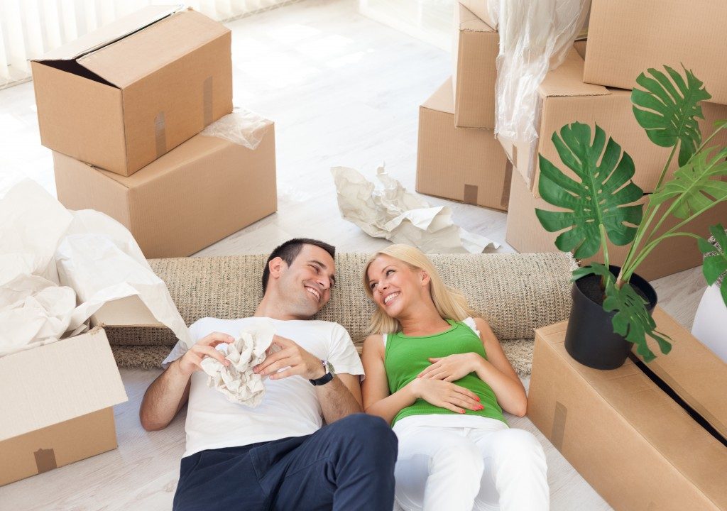 smiling couple relaxing in the middle of cardboard boxes