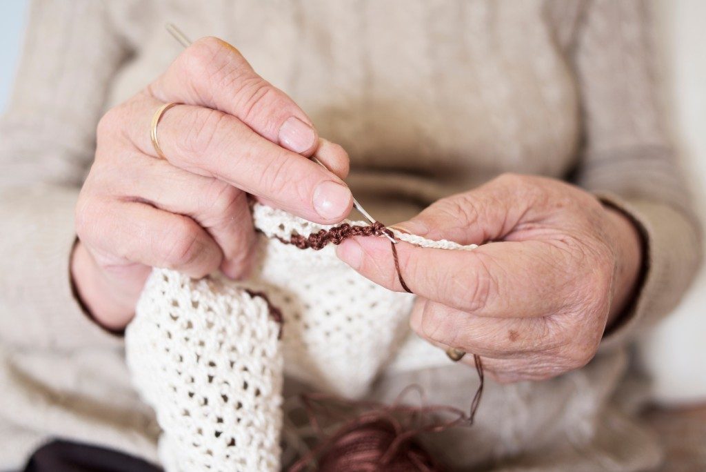 hands of an old person knitting
