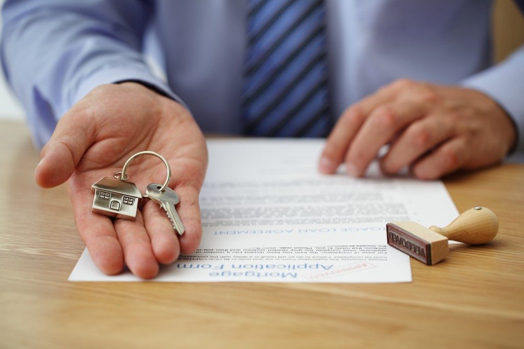 broker handing keys and approved application