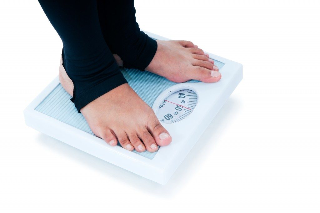 Close-up of a female feet standing on weighing scale.