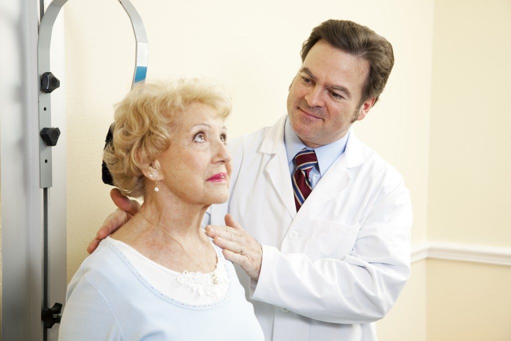 chiropractor treating an elderly woman