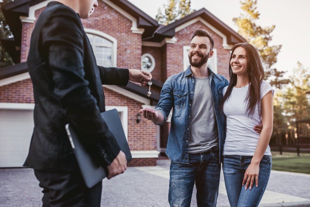 Realtor handing keys to new homeowners