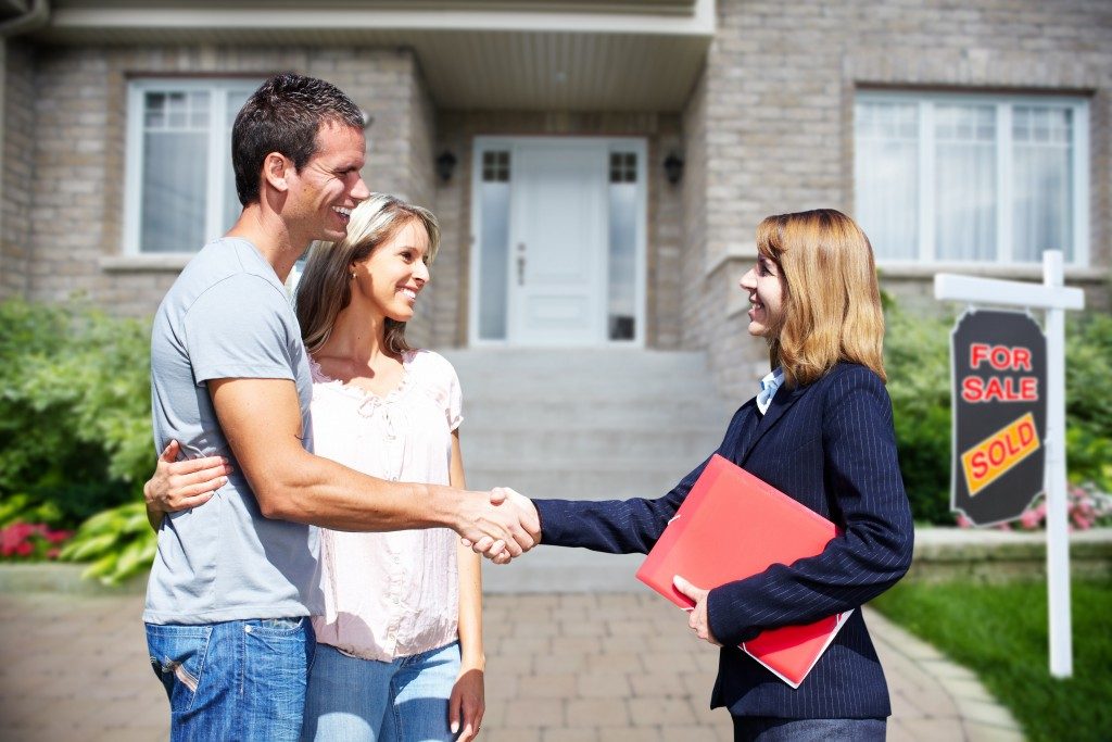 Realtor shaking hands of new homeowners