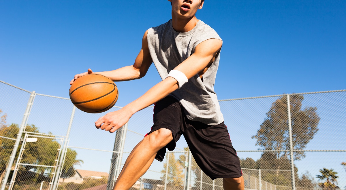 handsome male playing basketball