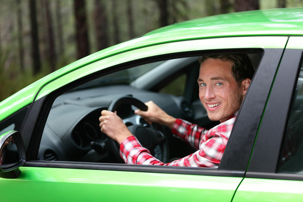 a green car with a male driver